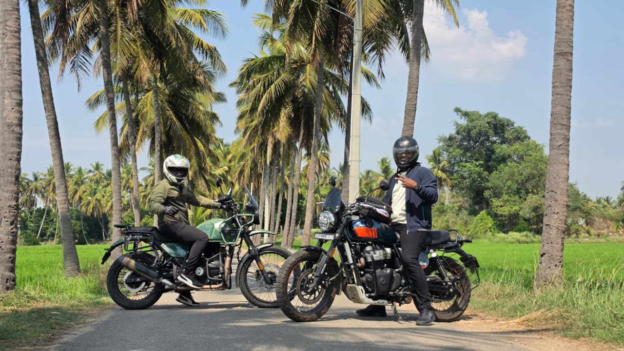 Two touring motorcycles on a palm-lined road near Bangalore
